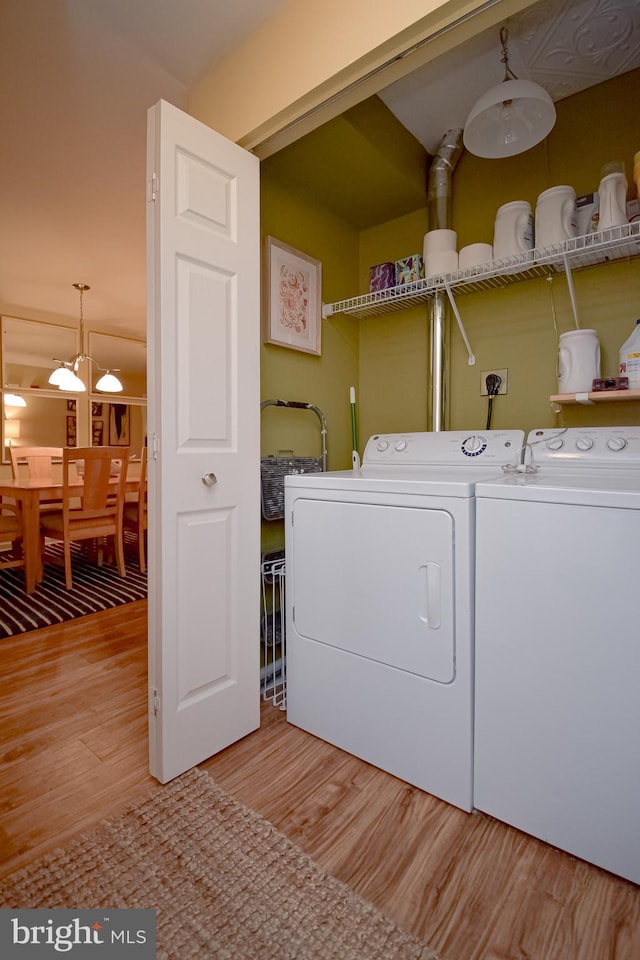 clothes washing area featuring light wood-type flooring and washing machine and dryer