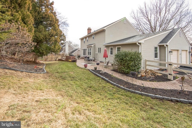 rear view of house featuring a garage, a patio, and a yard