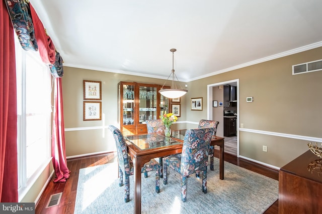 dining room featuring ornamental molding and dark hardwood / wood-style floors