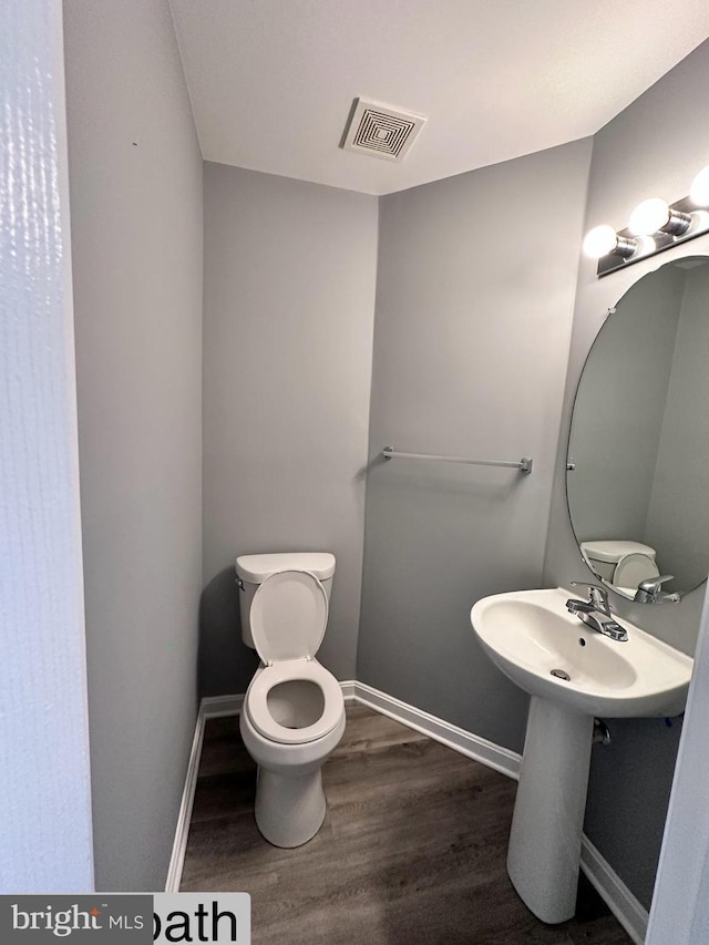 bathroom featuring toilet and wood-type flooring