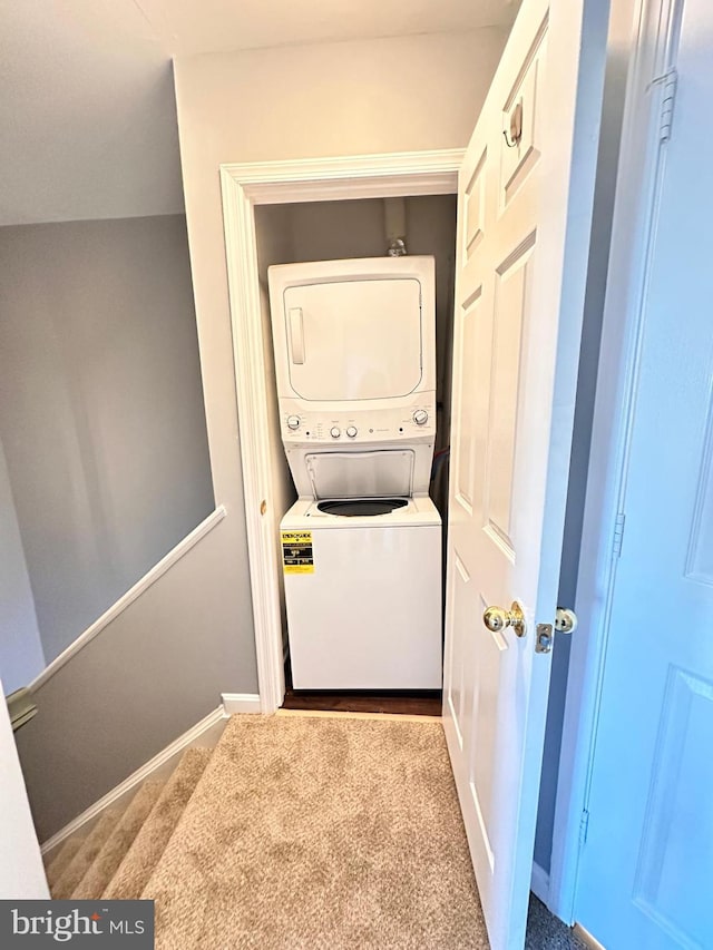 clothes washing area featuring light colored carpet and stacked washing maching and dryer