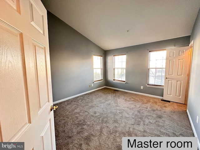 unfurnished bedroom with carpet flooring and lofted ceiling