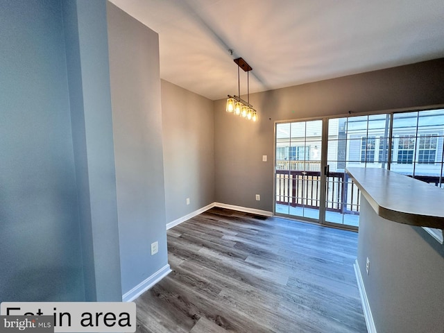 spare room featuring dark hardwood / wood-style flooring and a chandelier