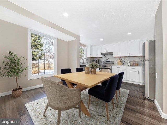 dining space with dark hardwood / wood-style floors and sink