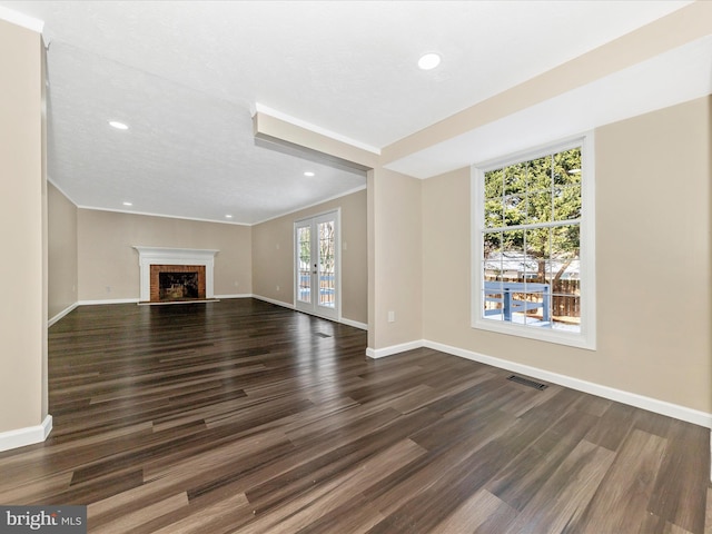 unfurnished living room with dark hardwood / wood-style floors, a fireplace, and french doors