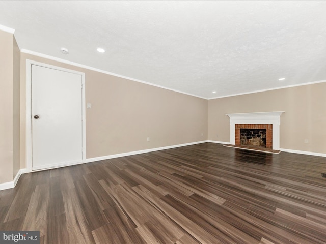 unfurnished living room with a fireplace, dark wood-type flooring, a textured ceiling, and ornamental molding