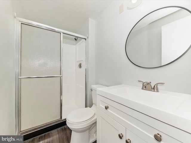 bathroom featuring walk in shower, vanity, wood-type flooring, and toilet