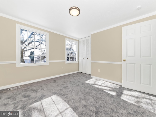 unfurnished room featuring carpet and crown molding