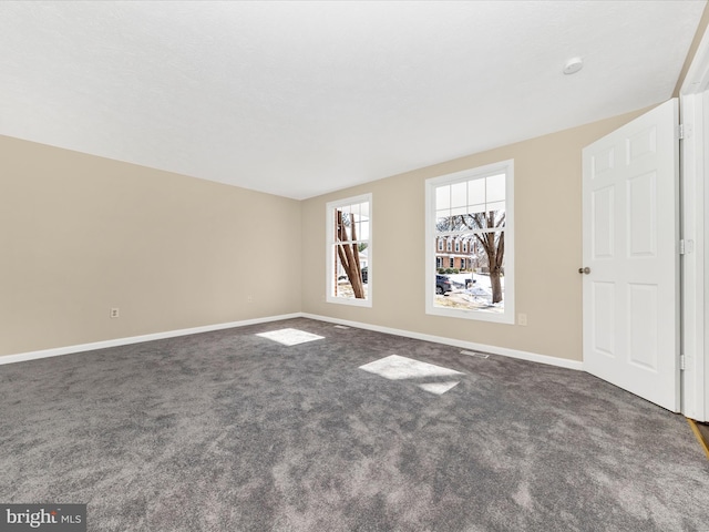 empty room featuring dark colored carpet