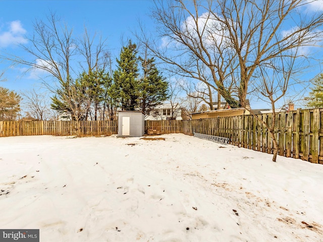 yard covered in snow featuring a storage shed