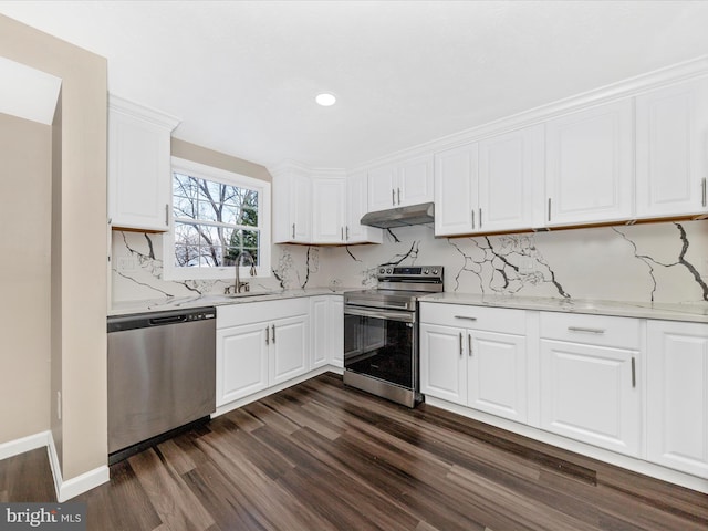 kitchen featuring white cabinets, stainless steel appliances, light stone counters, and sink