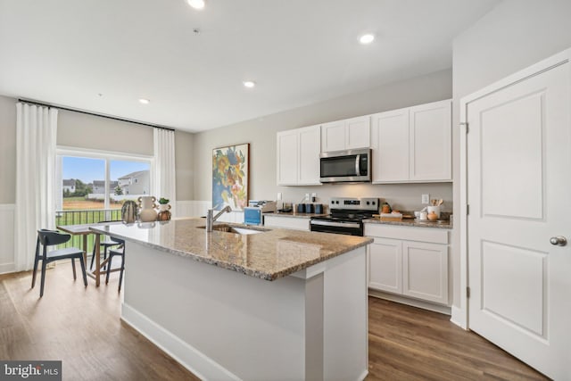 kitchen with white cabinets, sink, an island with sink, and appliances with stainless steel finishes