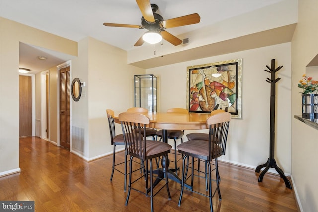 dining space featuring ceiling fan and dark hardwood / wood-style floors