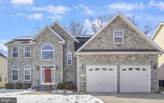 view of front of property featuring a garage, cooling unit, and solar panels