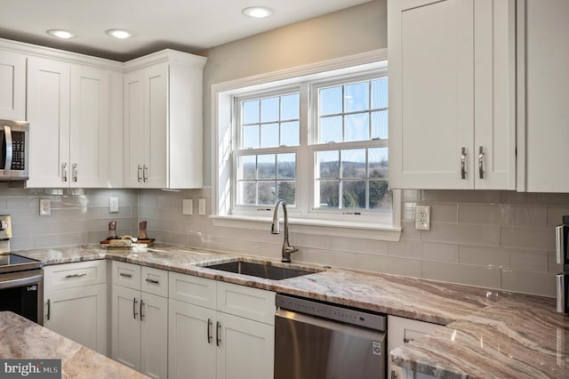 kitchen featuring white cabinets, appliances with stainless steel finishes, and sink