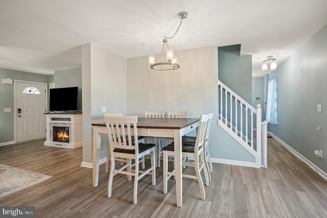 dining space with wood-type flooring and a chandelier