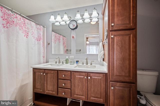 bathroom with ceiling fan, vanity, toilet, and walk in shower