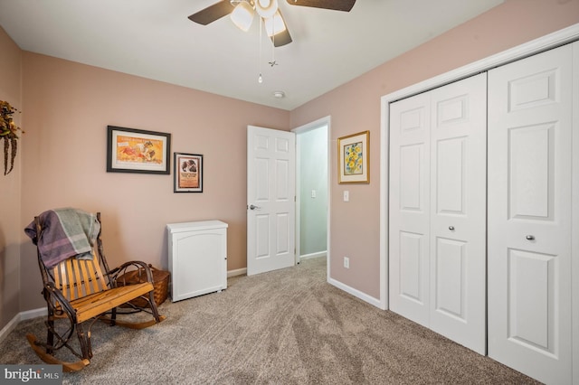 living area featuring light carpet and ceiling fan