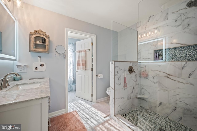 bathroom featuring tiled shower, vanity, and toilet