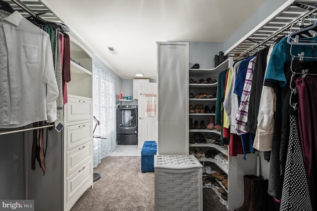 walk in closet featuring light colored carpet and washer / dryer