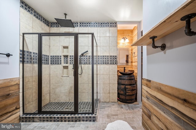 bathroom featuring a shower with door and wooden walls