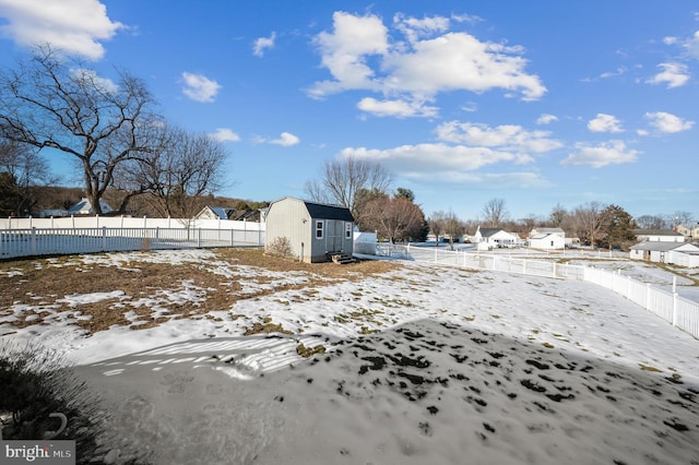 yard layered in snow featuring a storage shed