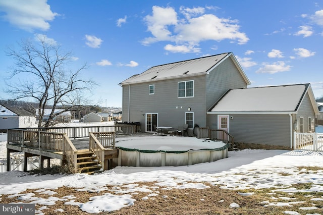 snow covered rear of property featuring a wooden deck