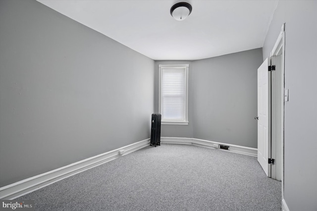 carpeted spare room with radiator, visible vents, and baseboards