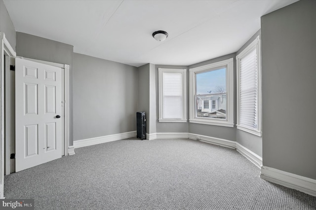 empty room featuring carpet floors and baseboards