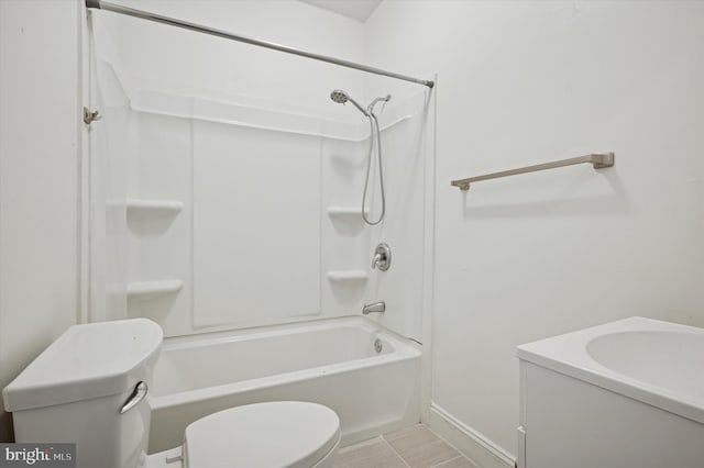 bathroom featuring toilet, shower / bath combination, and baseboards