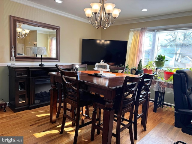 dining area with recessed lighting, an inviting chandelier, ornamental molding, and light wood finished floors