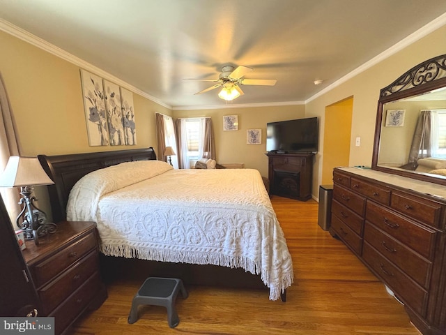 bedroom with crown molding, multiple windows, and wood finished floors