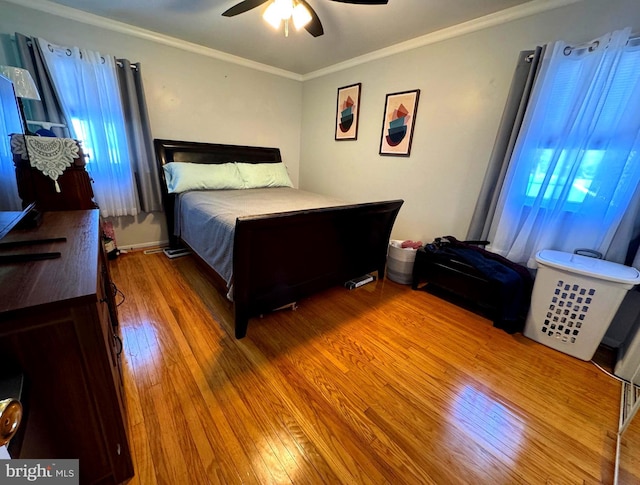 bedroom featuring hardwood / wood-style floors, crown molding, and ceiling fan