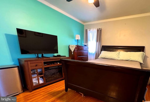 bedroom with crown molding, a ceiling fan, and wood finished floors