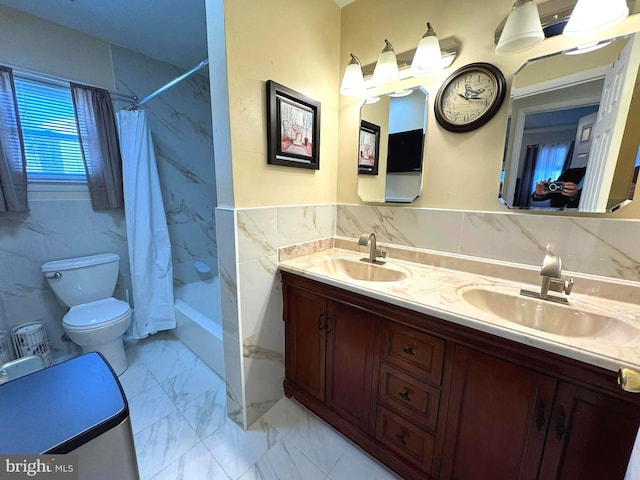 bathroom with tile walls, toilet, marble finish floor, and a sink