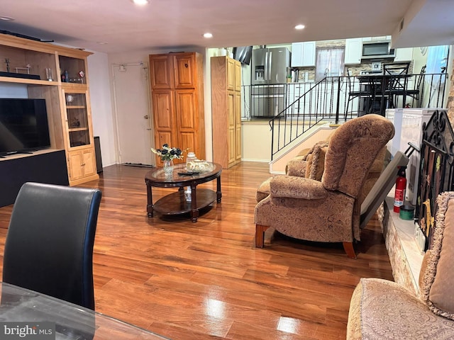 living area with stairway, recessed lighting, and wood finished floors