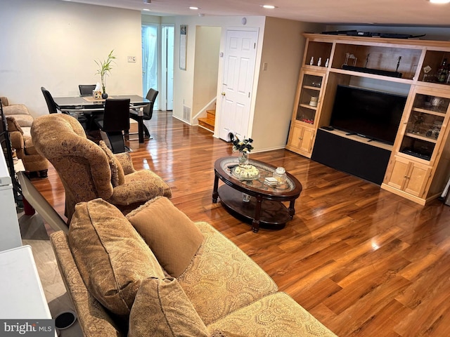 living room with stairway, wood finished floors, visible vents, baseboards, and recessed lighting