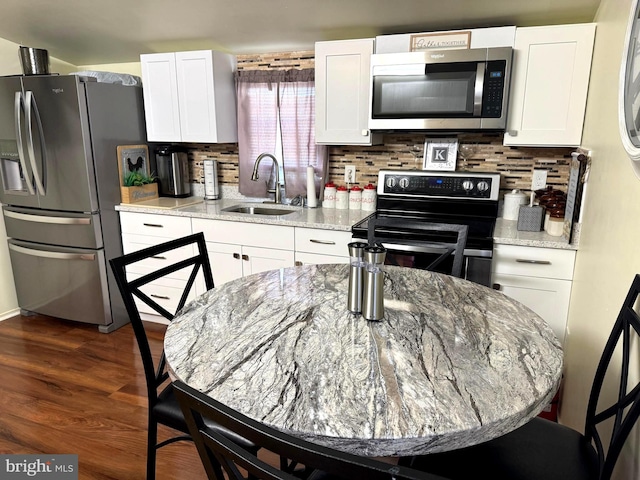 kitchen with white cabinets, dark wood-style flooring, appliances with stainless steel finishes, and a sink