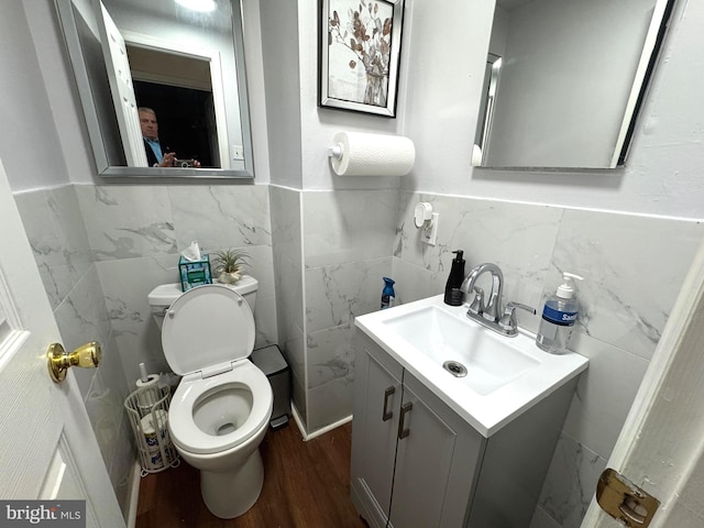 half bathroom featuring toilet, vanity, and wood finished floors