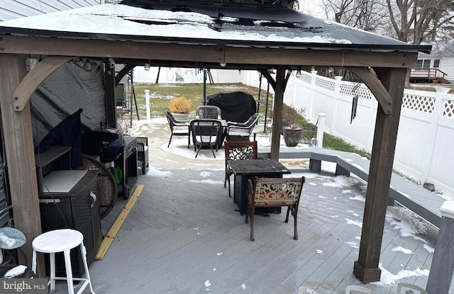 snow covered deck with a gazebo, fence, and grilling area