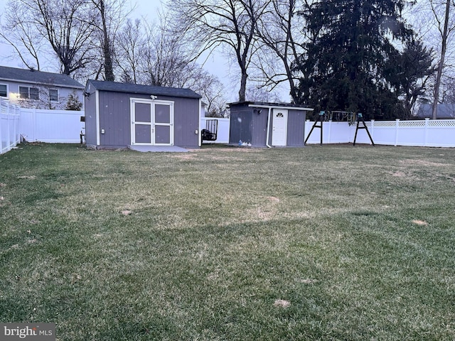 view of yard with an outdoor structure, a storage shed, and a fenced backyard