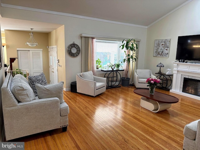 living area with ornamental molding, wood finished floors, a premium fireplace, baseboards, and vaulted ceiling