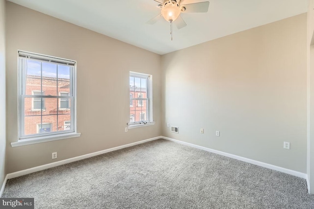 spare room featuring carpet, ceiling fan, and a healthy amount of sunlight