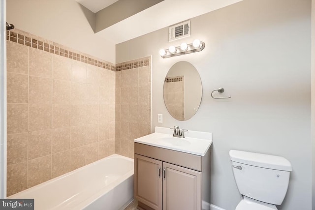 full bathroom featuring vanity, tiled shower / bath combo, and toilet