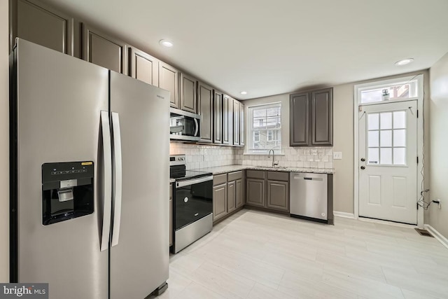 kitchen featuring decorative backsplash, sink, and appliances with stainless steel finishes