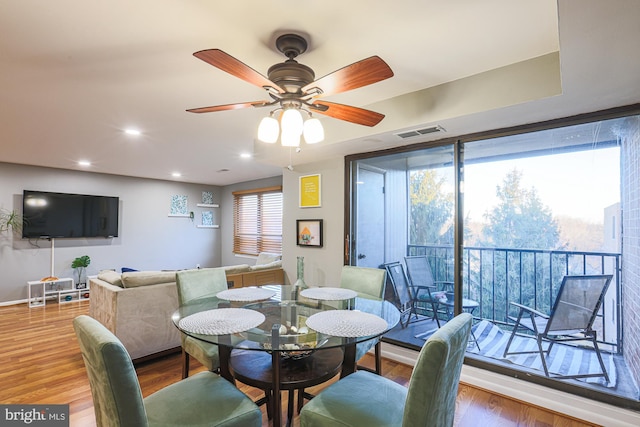 dining space with wood-type flooring and ceiling fan