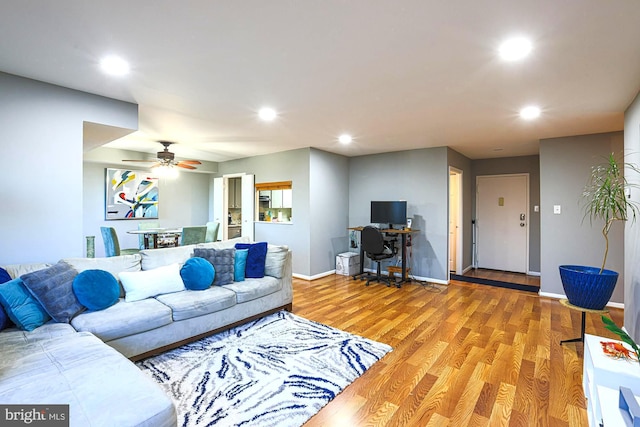 living room with light hardwood / wood-style floors and ceiling fan