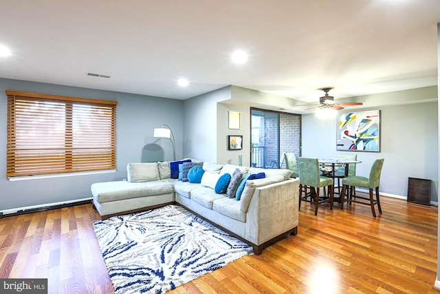 living room featuring light hardwood / wood-style floors and ceiling fan