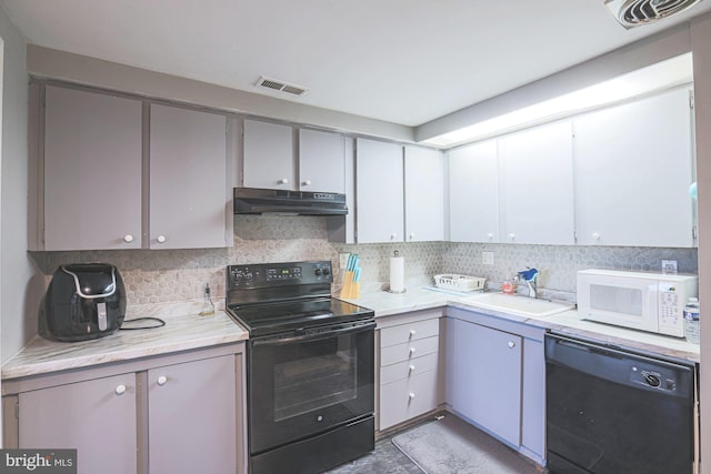 kitchen with gray cabinetry, decorative backsplash, sink, and black appliances