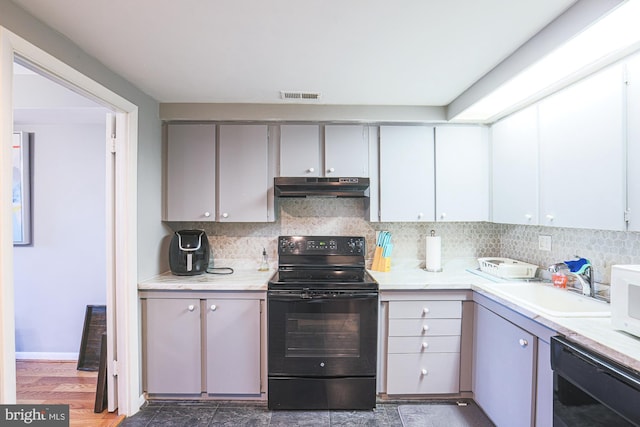 kitchen featuring black appliances, gray cabinetry, sink, and tasteful backsplash